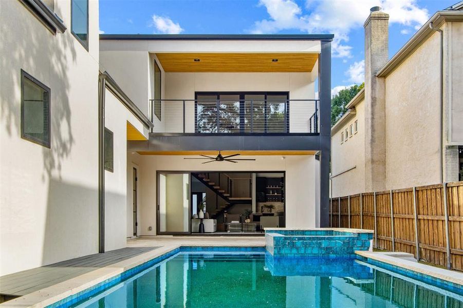 Back of property with a balcony, a fenced in pool, and ceiling fan