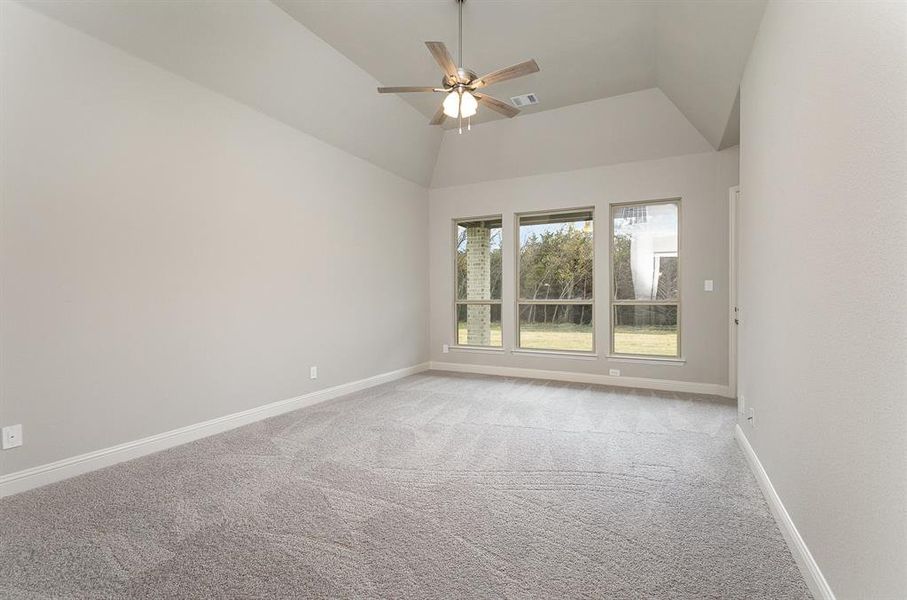 Unfurnished room featuring light carpet, ceiling fan, and lofted ceiling