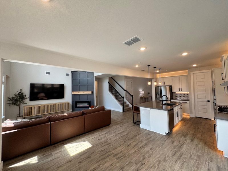 Kitchen featuring recessed lighting, a breakfast bar, hanging light fixtures, a kitchen island with sink, and a fireplace