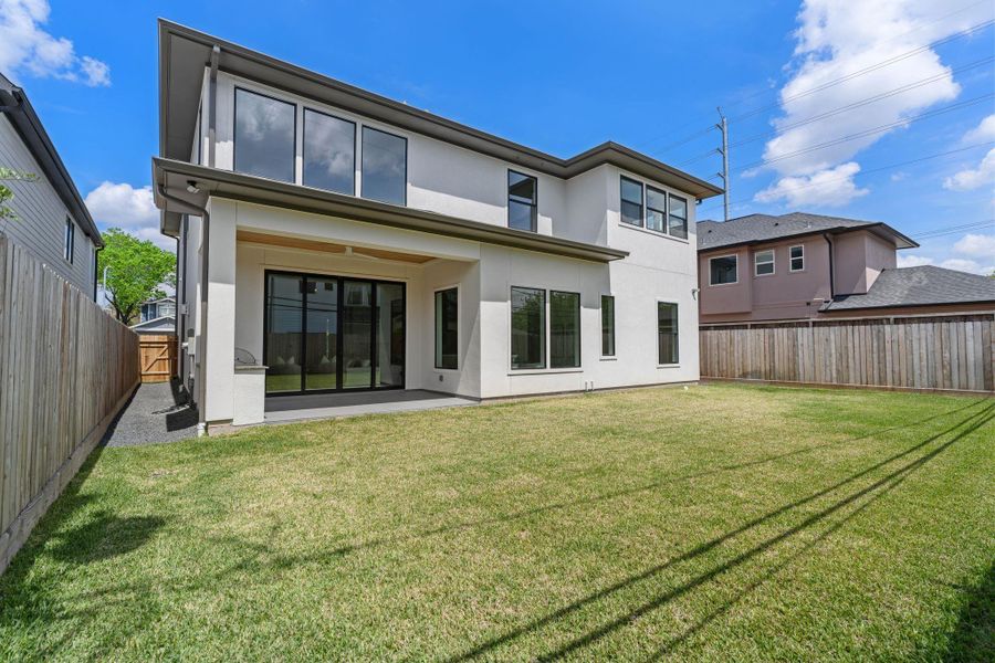 A spacious, fully fenced backyard offers plenty of room for entertaining, play, or future pool plans, with clean landscaping and open green space.
