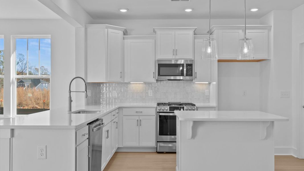 Accomplished kitchen design featuring pendant lighting above a statement island for both prep and gathering
