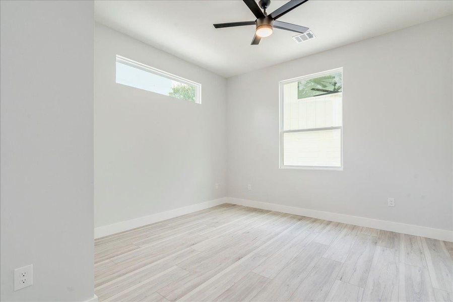 Secondary room with ceiling fan and light wood finished floors Secondary room with ceiling fan and light wood finished floors