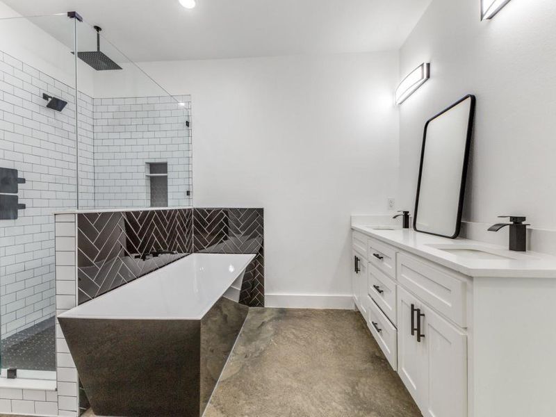 Bathroom featuring double vanity, a soaking tub, a tile shower, and a walk in closet.