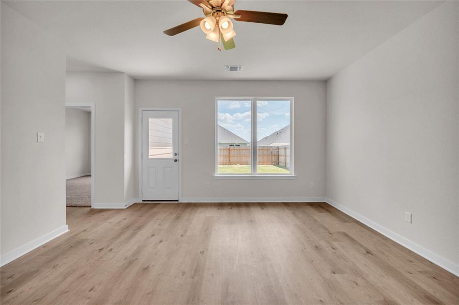 Unfurnished living room with light wood finished floors and a ceiling fan Unfurnished living room with light wood finished floors and a ceiling fan