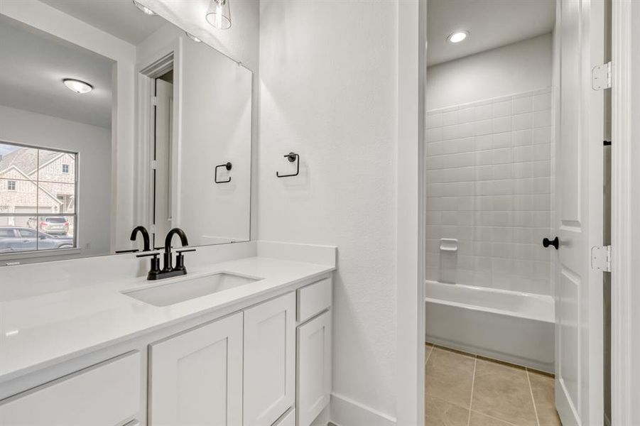 Full bathroom with vanity, light tile patterned floors, and bathing tub / shower combination