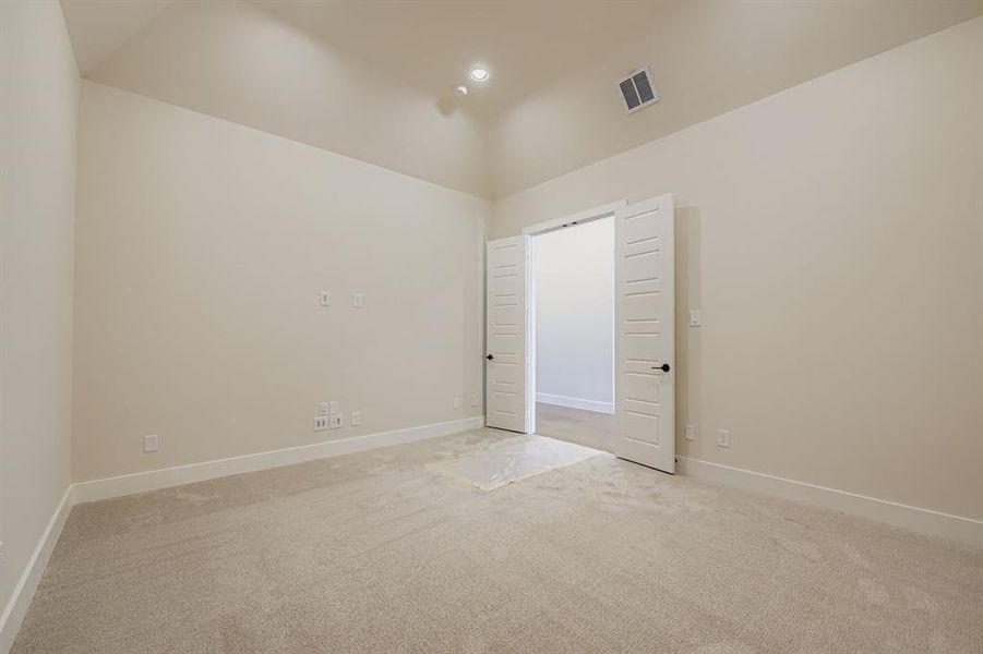 Empty room with carpet floors and lofted ceiling