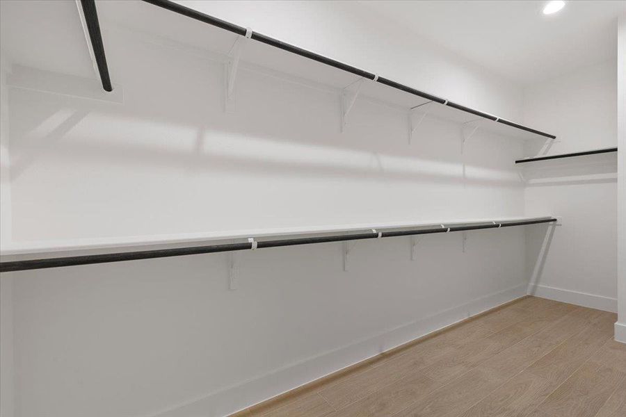 Spacious closet featuring light wood-style floors Spacious closet featuring light wood-style floors