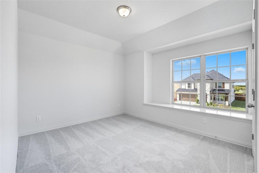 Unfurnished room with light carpet and lofted ceiling Unfurnished room with light carpet and lofted ceiling