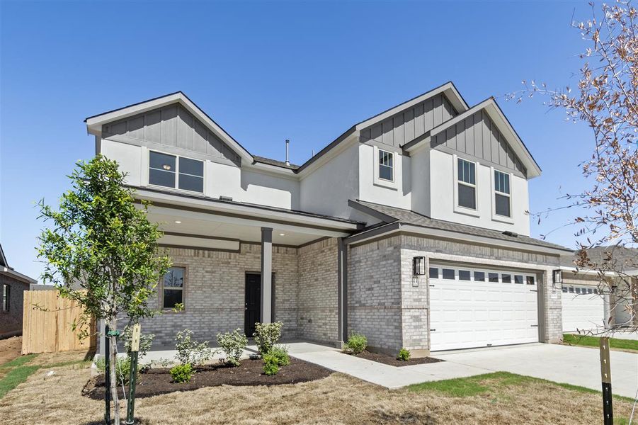 View of front of home with driveway, board and batten siding, brick siding, a garage, and fence View of front of home with driveway, board and batten siding, brick siding, a garage, and fence