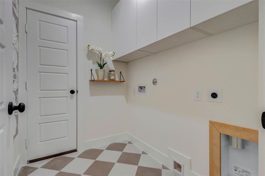 The dedicated laundry room combines practicality with modern design, featuring built-in cabinetry for storage and a clean, organized layout. Ample wall space and utility connections make this area highly functional for everyday tasks, while simple finishes keep the space bright and efficient. The picture shown is from the model home with the same floor plan, Rev floor plan.
