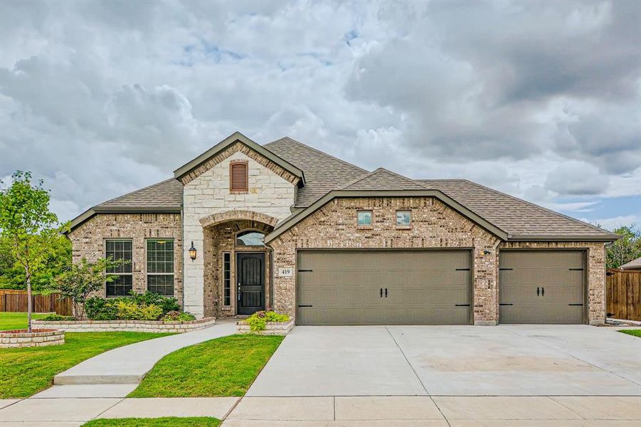 View of front of home with a garage and a front lawn