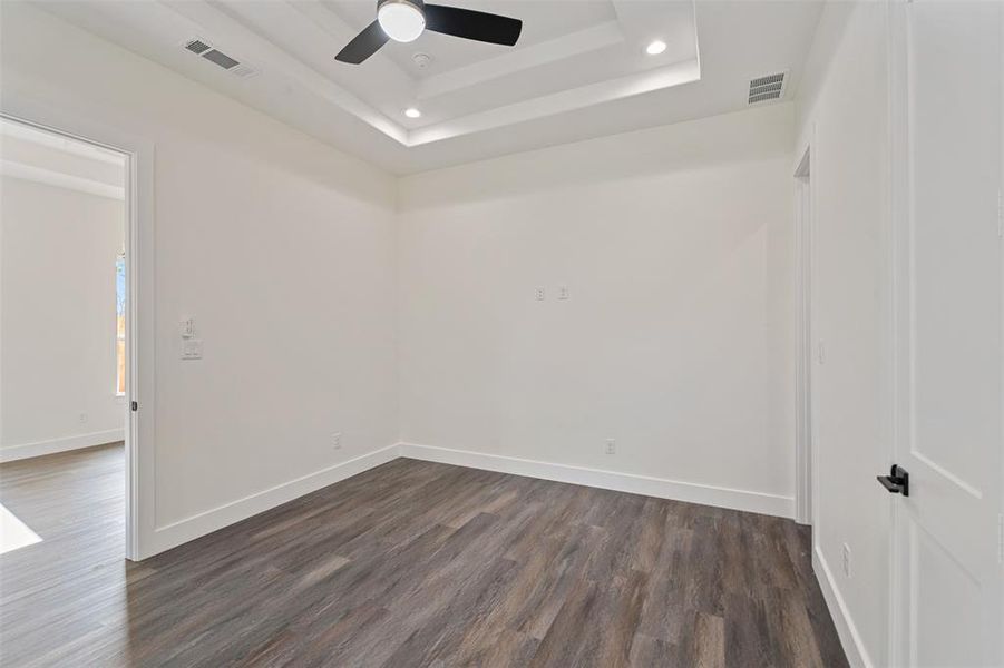 Unfurnished room featuring a tray ceiling, dark wood-type flooring, recessed lighting, and ceiling fan Unfurnished room featuring a tray ceiling, dark wood-type flooring, recessed lighting, and ceiling fan