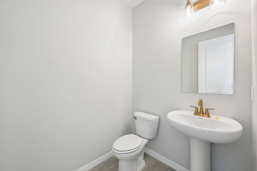 Down the hallway near the dining nook you will find the half bathroom featuring aspects of AW Collection® Sapphire