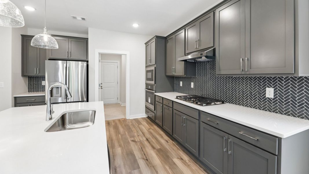 Kitchen with quarts countertops, pendant lighting, and hard surface flooring