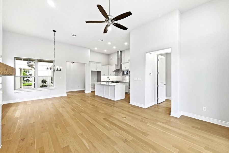 Open-concept living space featuring wood-finish flooring, a contemporary ceiling fan, and recessed lighting