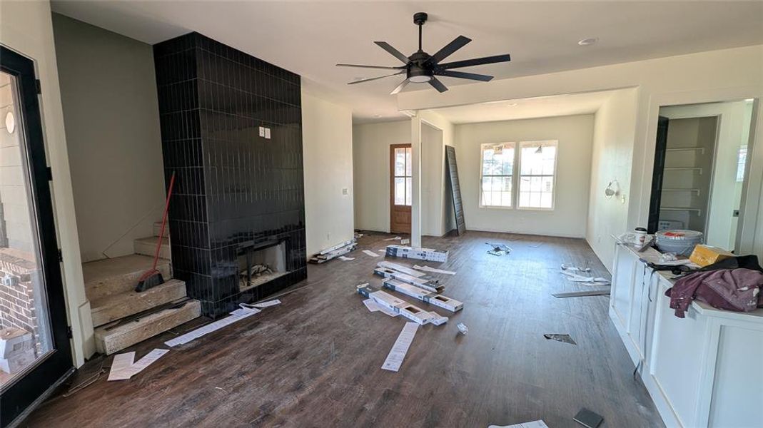 Unfurnished living room with wood finished floors and ceiling fan