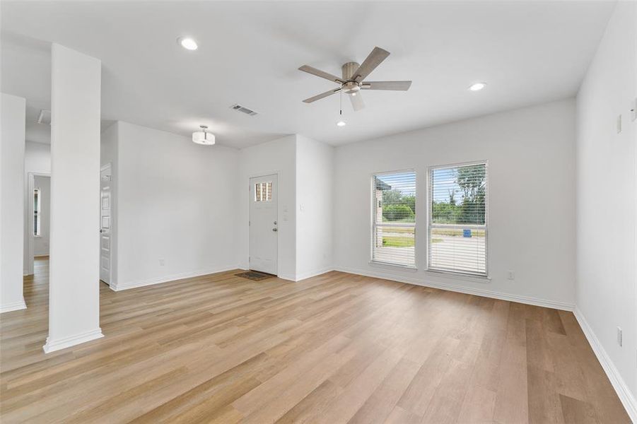 Open-concept living area featuring wood-finish flooring, recessed lighting, and a ceiling fan
