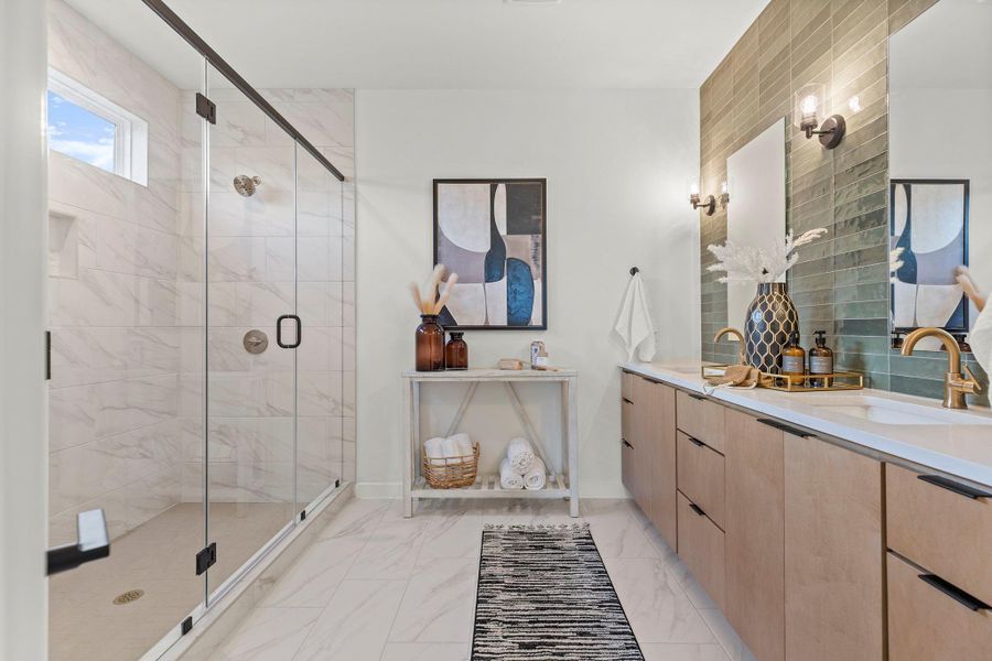 Full bath with double vanity, a marble finish shower, and light marble finish flooring