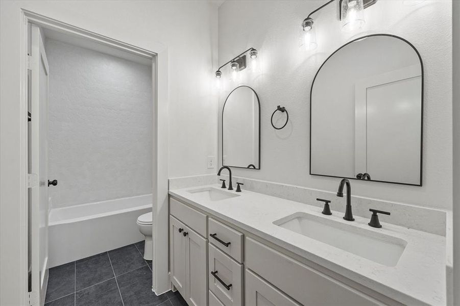 Full bathroom featuring vanity, tile patterned floors, shower / bathtub combination, and toilet