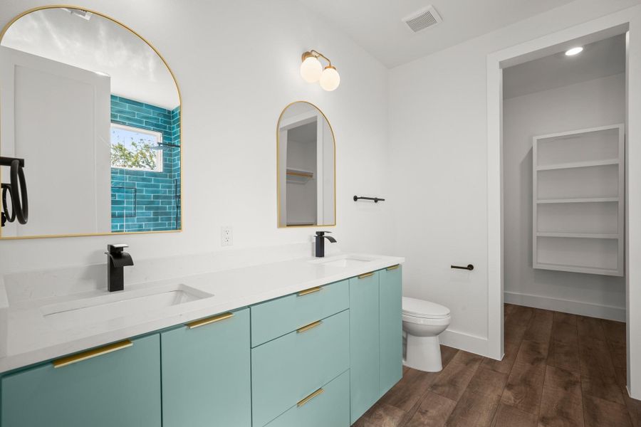 Bathroom featuring double vanity and dark wood-style floors