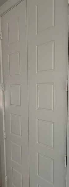 White bi-fold doors featuring recessed panel detailing and visible hinges White bi-fold doors featuring recessed panel detailing and visible hinges