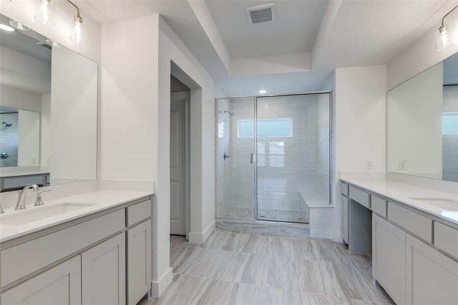 Bathroom featuring tile floors, a shower with shower door, and vanity