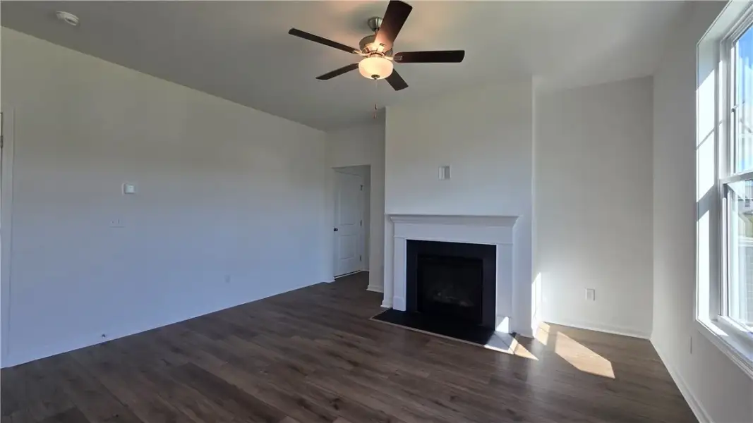 Rich wood flooring runs throughout the airy living
