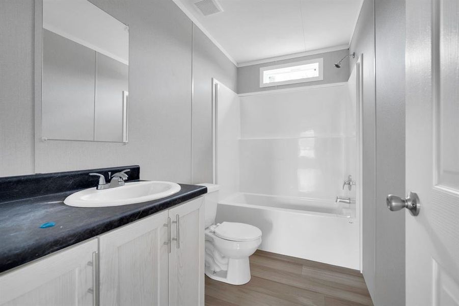 Bathroom featuring vanity,  shower combination, and light wood-type flooring