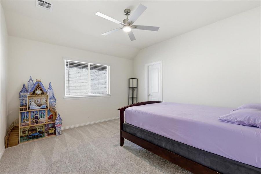 Carpeted room featuring a single window with blinds, a ceiling fan with integrated lighting, and a white interior door