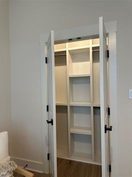 Built-in closet system featuring white shelving and hanging rods