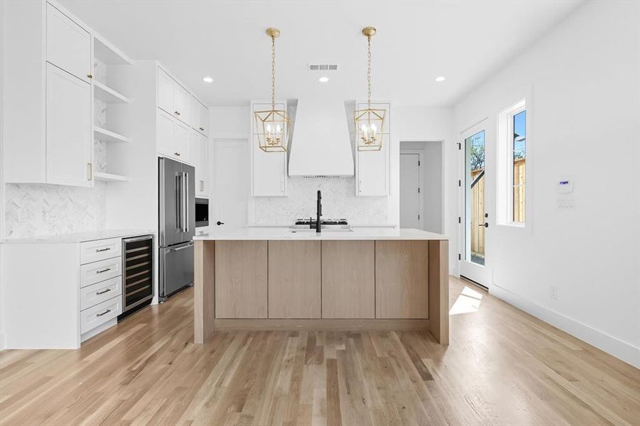 Kitchen with open shelves, light stone countertops, white cabinetry, decorative light fixtures, and recessed lighting Kitchen with open shelves, light stone countertops, white cabinetry, decorative light fixtures, and recessed lighting