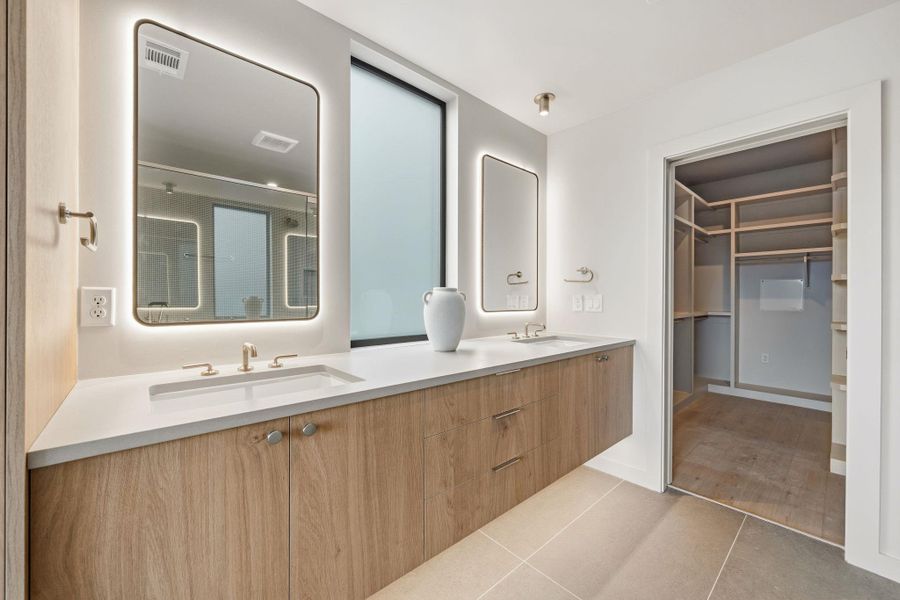 Modern double vanity with clean lines, ample counter space, and integrated back-lit mirrors. Modern double vanity with clean lines, ample counter space, and integrated back-lit mirrors.