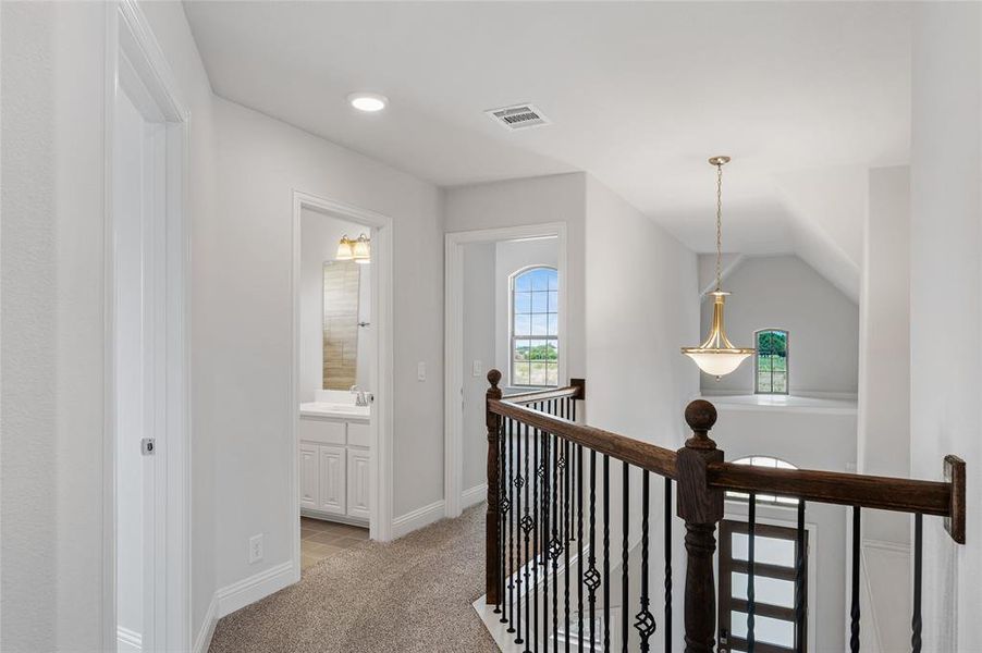 Hall featuring light carpet and an upstairs landing