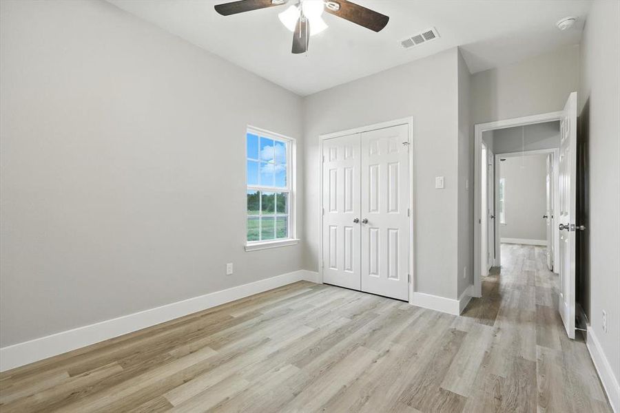 Unfurnished bedroom featuring a closet, light wood-style floors, and a ceiling fan Unfurnished bedroom featuring a closet, light wood-style floors, and a ceiling fan