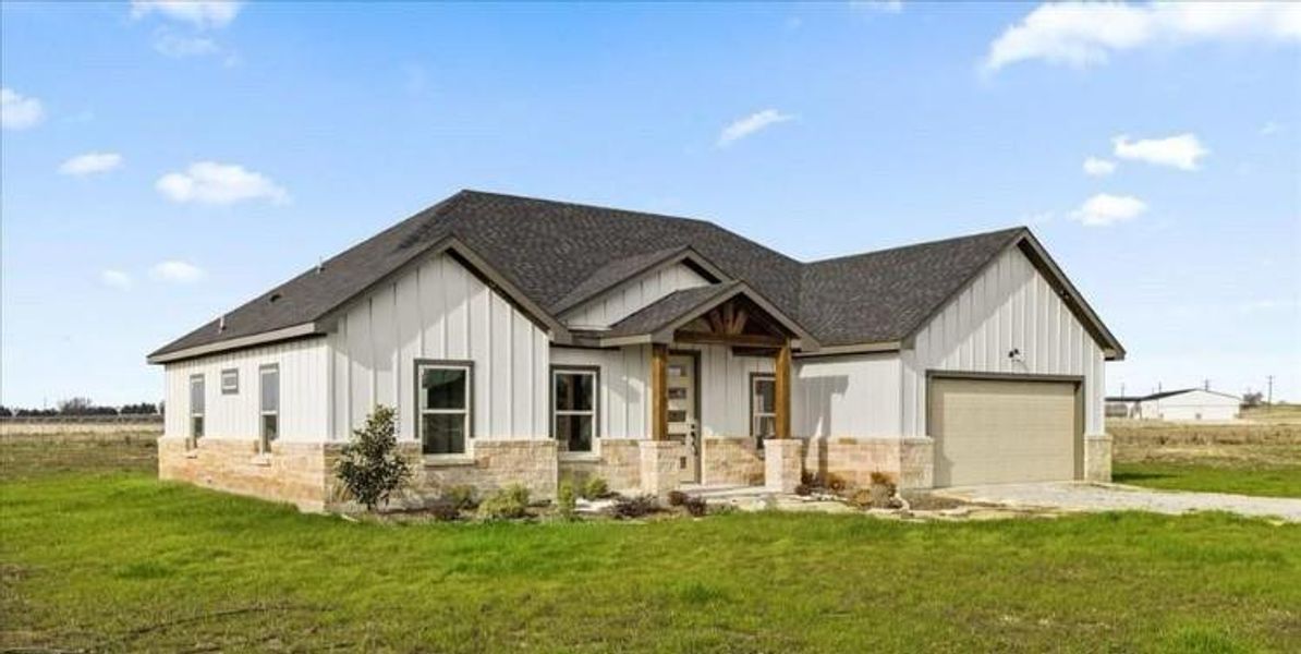 Modern farmhouse style home with a garage and a front lawn