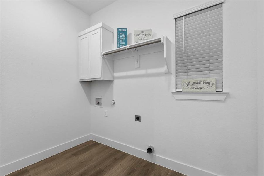 Laundry room with cabinets, dark hardwood / wood-style floors, hookup for an electric dryer, hookup for a washing machine, and hookup for a gas dryer