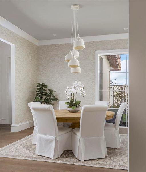 Dining space with light wood finished floors and wallpapered walls Dining space with light wood finished floors and wallpapered walls