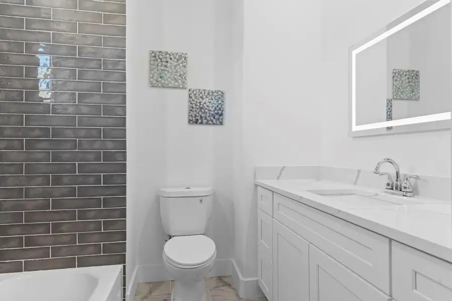 Relax and unwind in a stylish bath complete with a deep soaking tub.