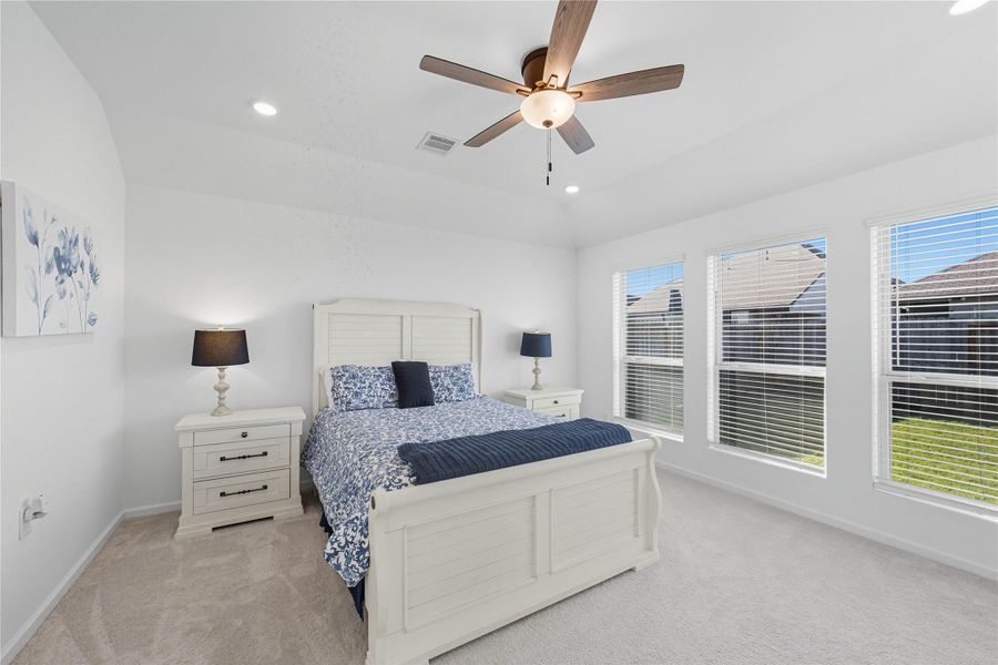 Bright and spacious master bedroom with large windows, neutral carpet, and a ceiling fan. Bright and spacious master bedroom with large windows, neutral carpet, and a ceiling fan.