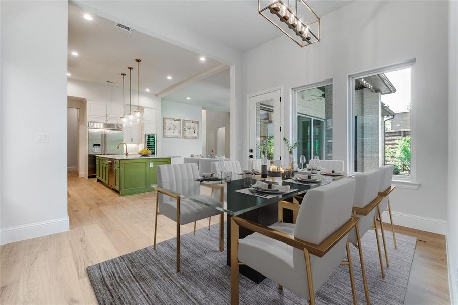 Dining room with light wood-style flooring, recessed lighting, and a chandelier Dining room with light wood-style flooring, recessed lighting, and a chandelier