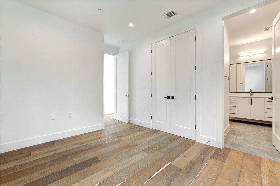 Unfurnished bedroom with light wood-style flooring, recessed lighting, and a closet