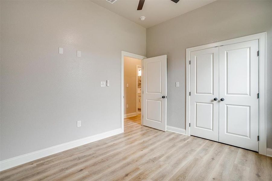 Unfurnished bedroom featuring baseboards, ceiling fan, a closet, and light wood-style flooring Unfurnished bedroom featuring baseboards, ceiling fan, a closet, and light wood-style flooring