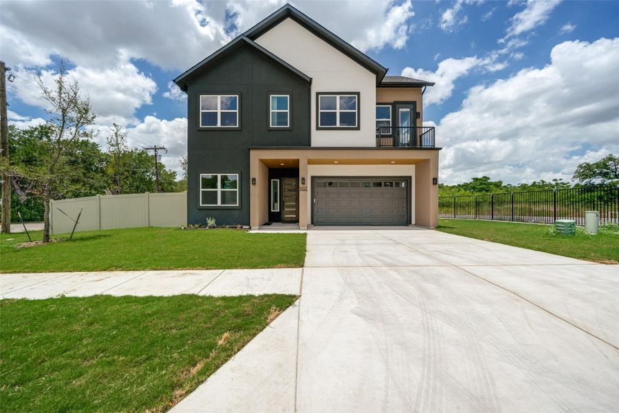 A striking modern facade featuring a two-car garage and a small balcony offers stylish curb appeal. A striking modern facade featuring a two-car garage and a small balcony offers stylish curb appeal.