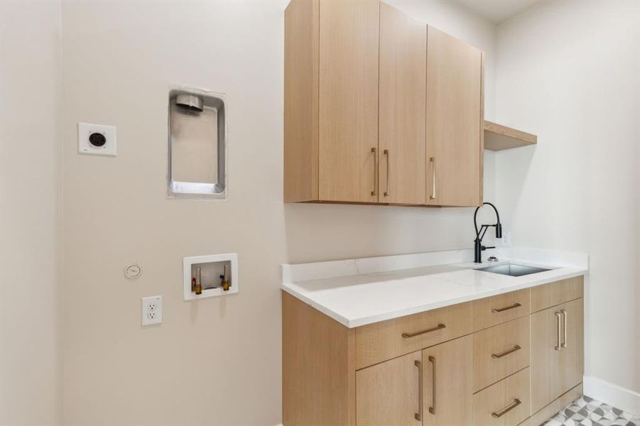 Washroom featuring hookup for an electric dryer, hookup for a washing machine, gas dryer hookup, baseboards, and cabinet space