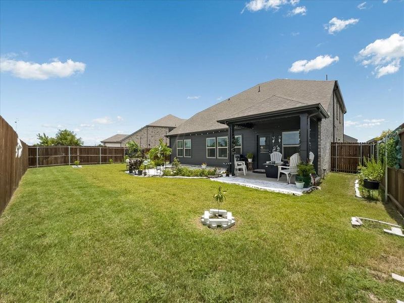 Rear view of property featuring a lawn and a patio area