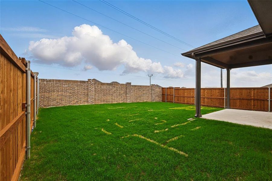 Fenced backyard with a patio