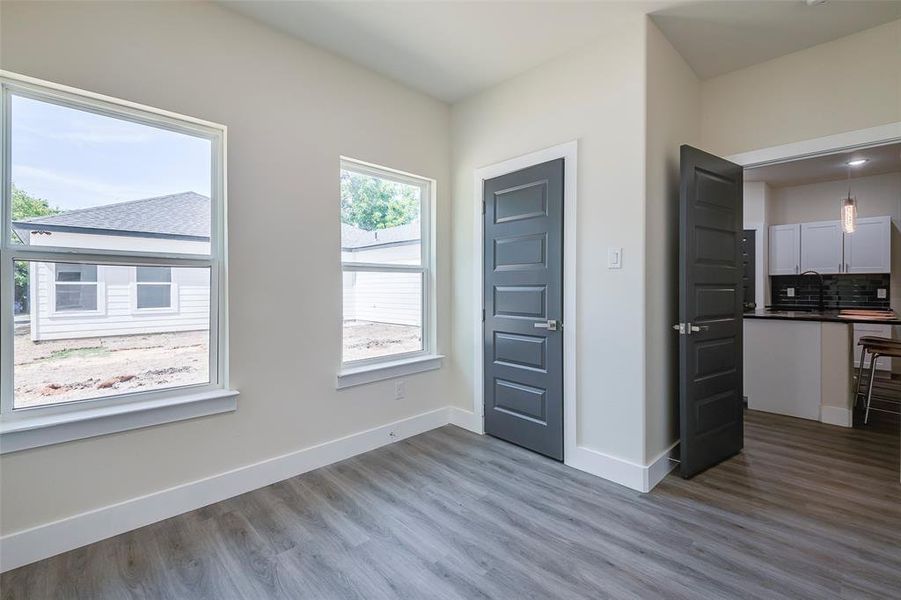 Unfurnished bedroom with hardwood / wood-style floors, sink, and multiple windows