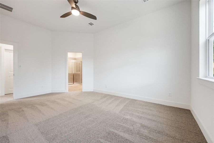 Unfurnished bedroom featuring light colored carpet, ceiling fan, and ensuite bathroom Unfurnished bedroom featuring light colored carpet, ceiling fan, and ensuite bathroom