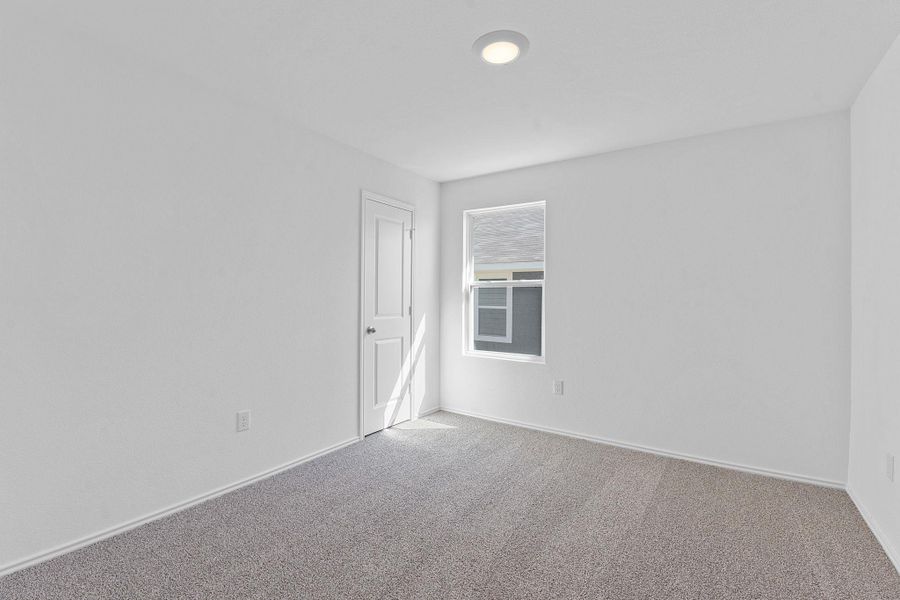 Spare room featuring carpet floors and baseboards