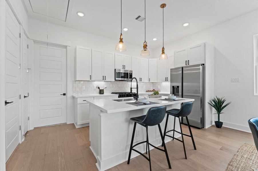 This stylish kitchen features sleek quartz countertops that offer both durability and elegance, paired with a spacious center island perfect for meal prep and casual dining. Surrounding the space is a generous array of cabinets, providing ample storage while maintaining a clean, streamlined look. The open layout and contemporary finishes create a welcoming atmosphere ideal for both everyday living and entertaining.